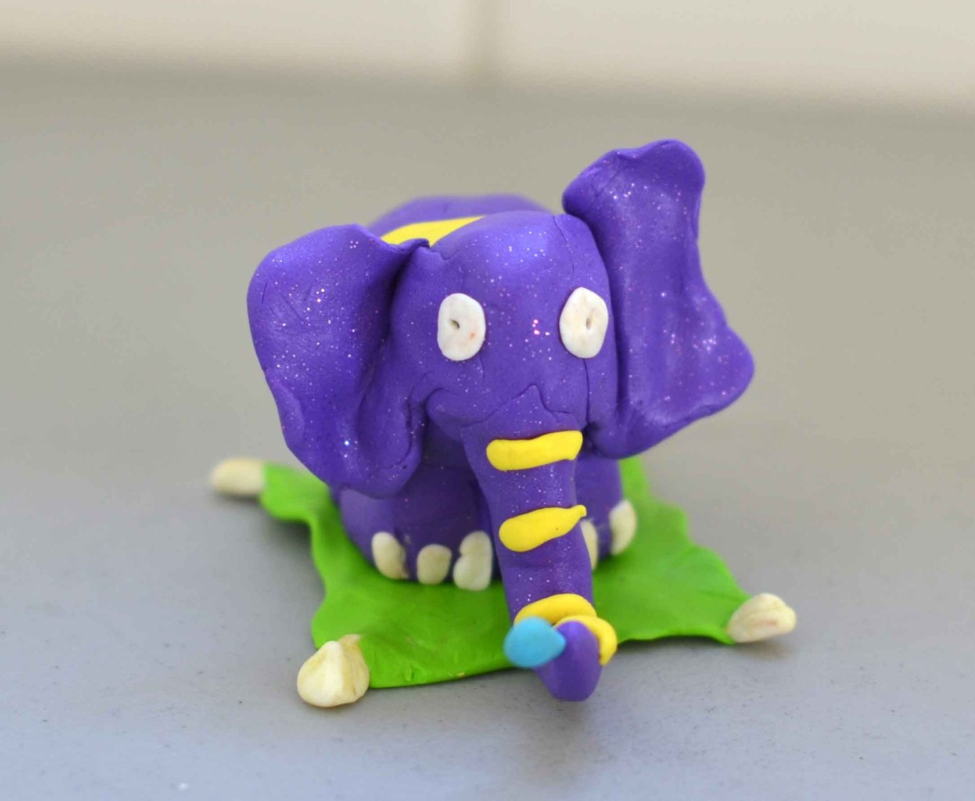 A child's purple clay elephant photographed on a table